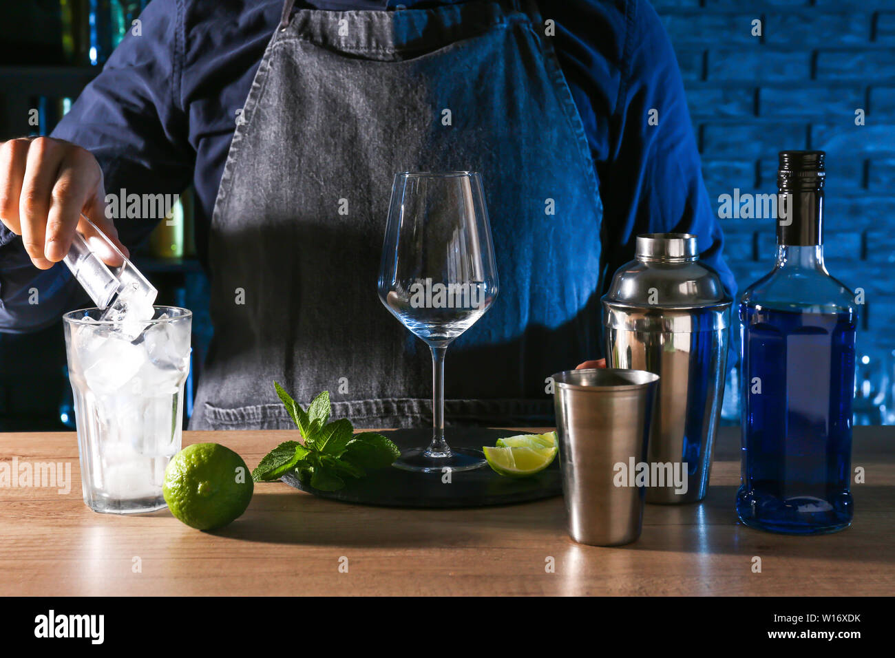 Barkeeper preparing Blue Lagoon cocktail at table in bar Stock Photo