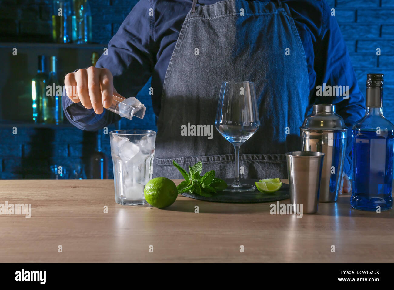 Barkeeper preparing Blue Lagoon cocktail at table in bar Stock Photo