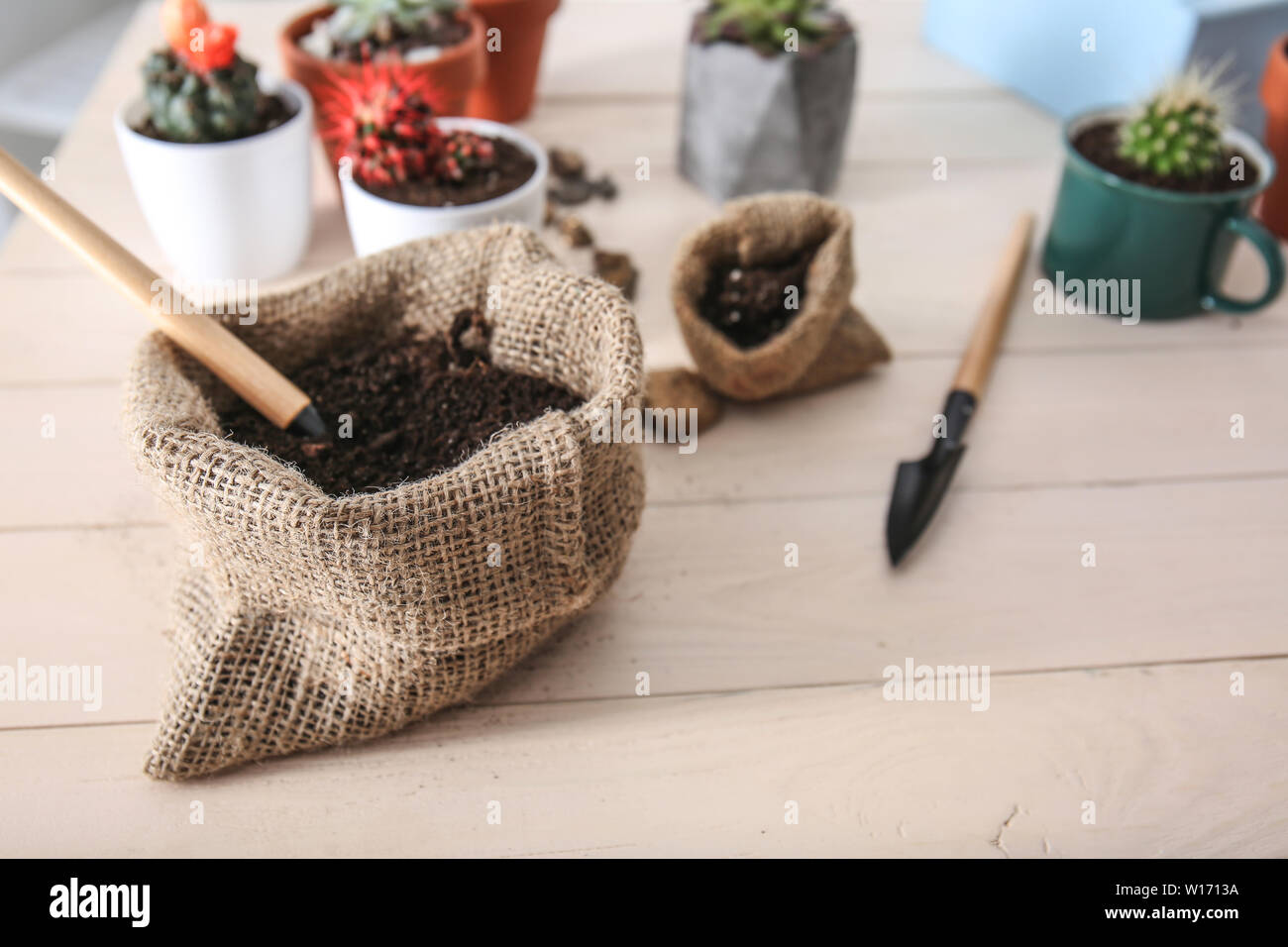 Bag with soil on wooden table Stock Photo