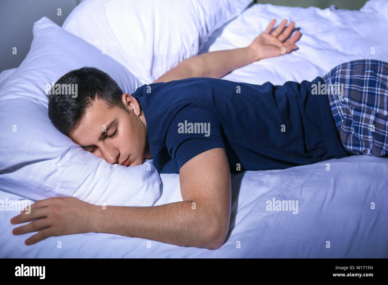 Young man sleeping in bed at night Stock Photo Alamy