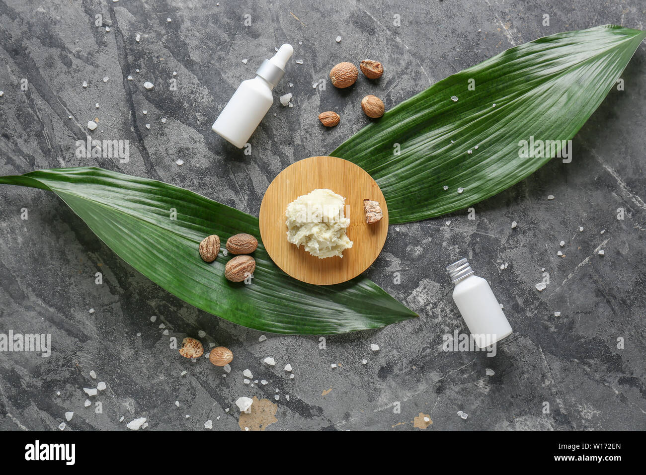 Shea butter with cosmetic products on grey background Stock Photo - Alamy