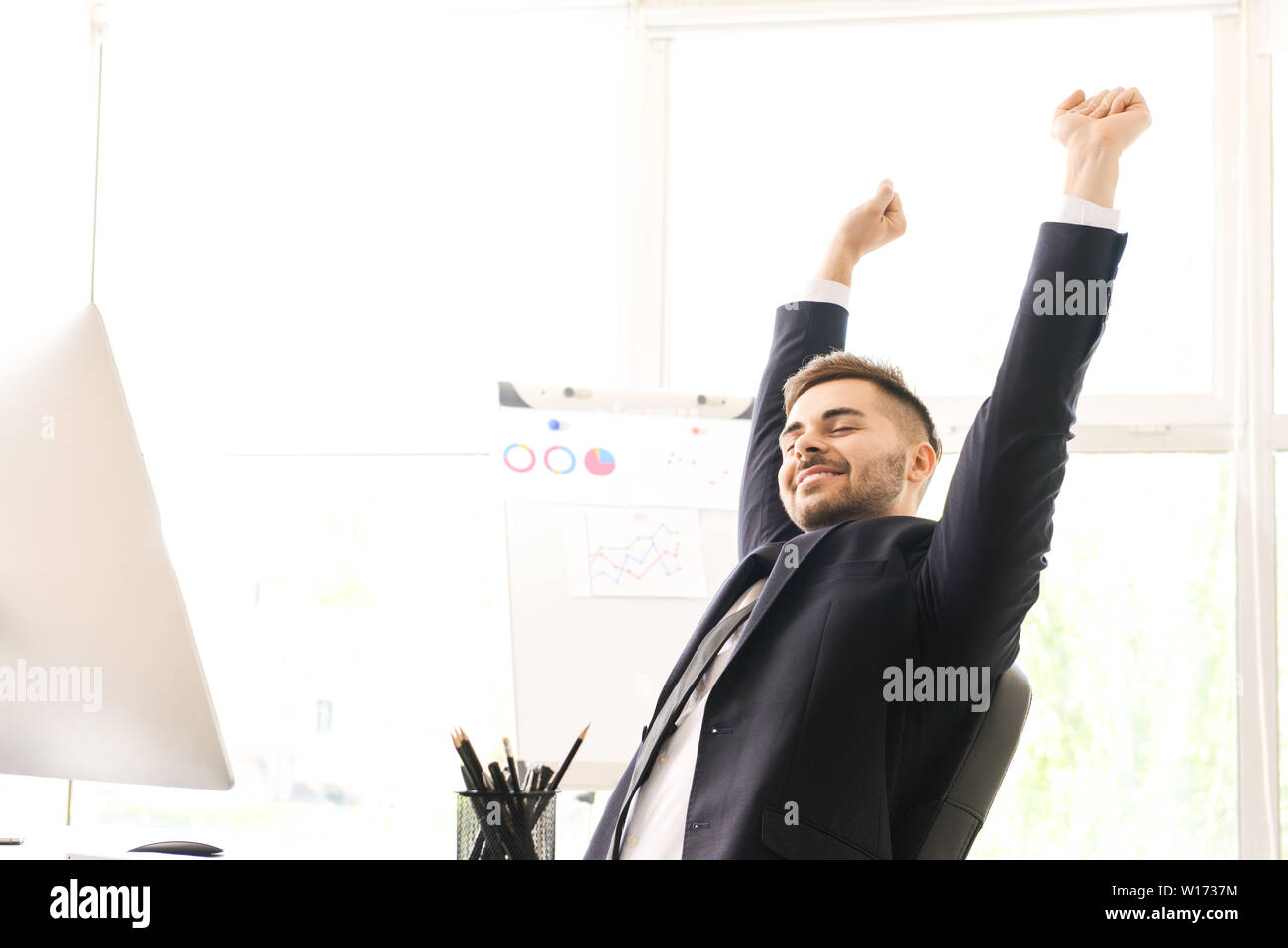Handsome businessman having break during work in office Stock Photo