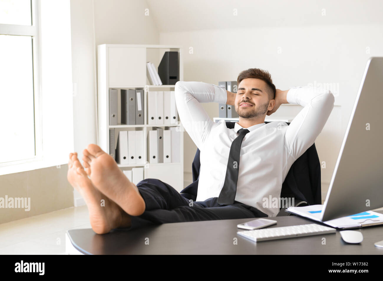 Handsome businessman having break during work in office Stock Photo