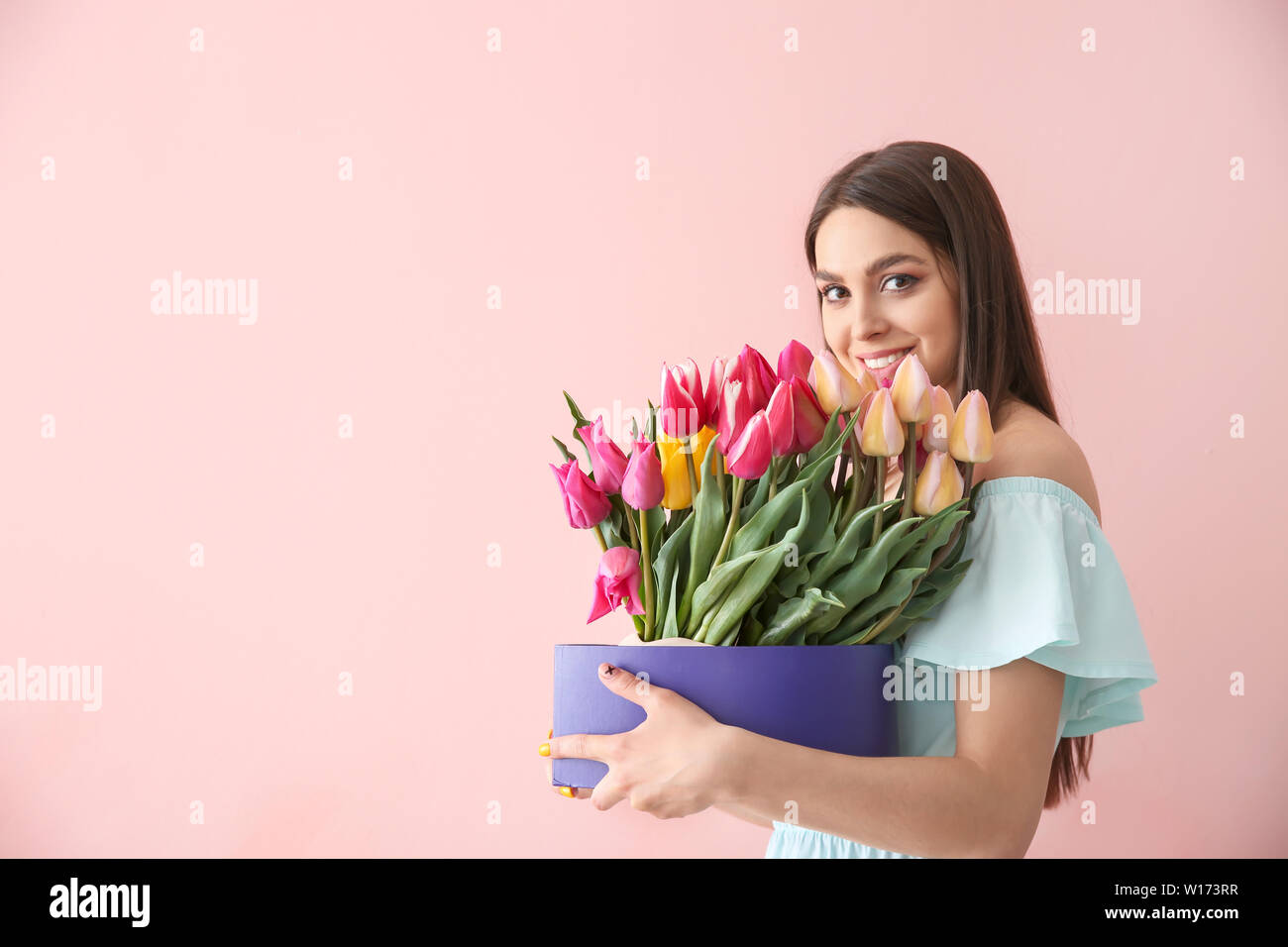 Beautiful young woman with bouquet of flowers on color background Stock ...