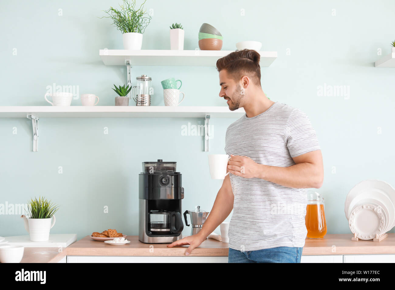 Handsome man using coffee machine in kitchen Stock Photo Alamy