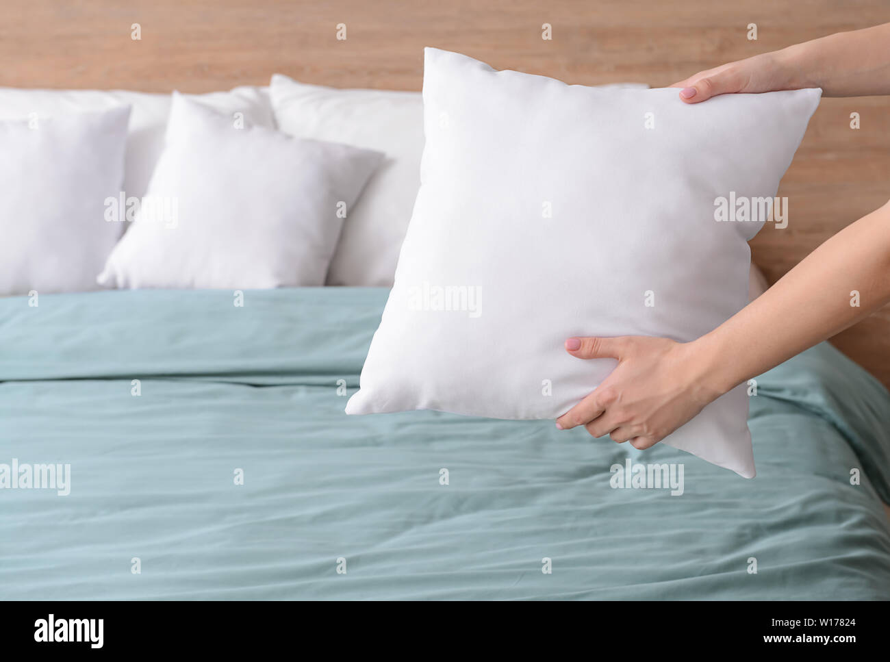 Woman fluffing soft pillows on bed Stock Photo Alamy
