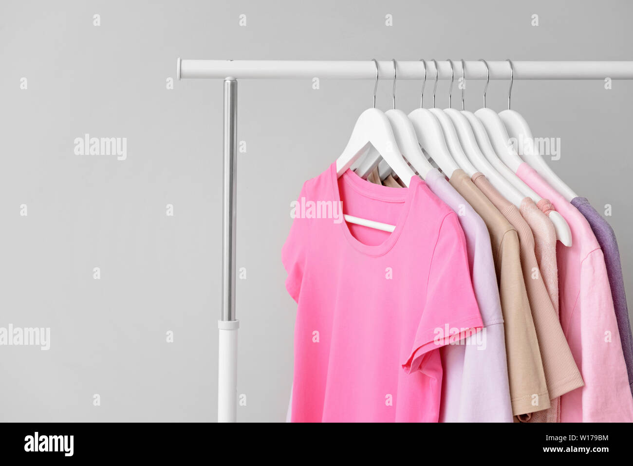 Rack with clothes after dry-cleaning on light background Stock Photo