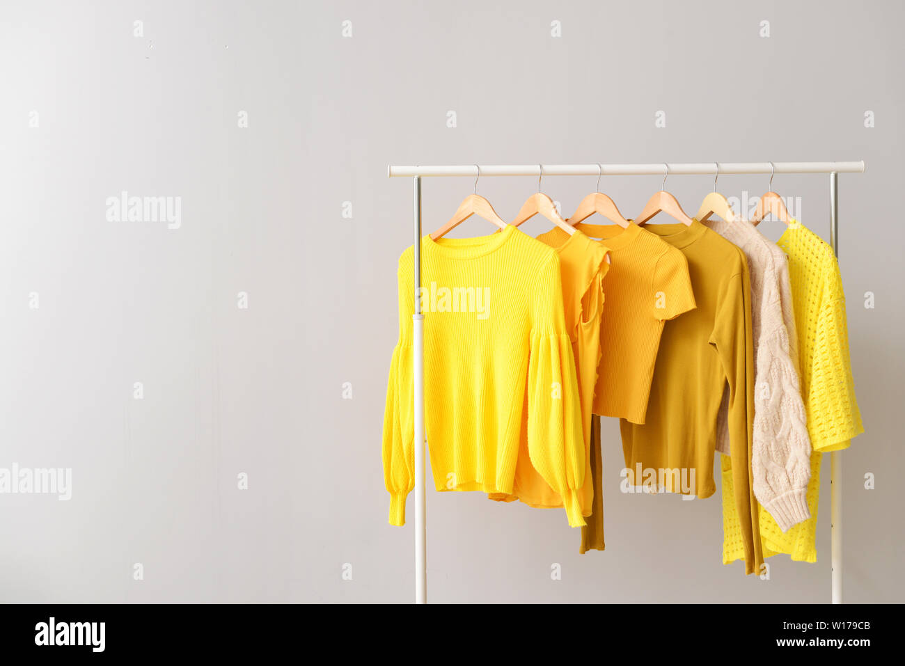 Rack with clothes after dry-cleaning on light background Stock Photo