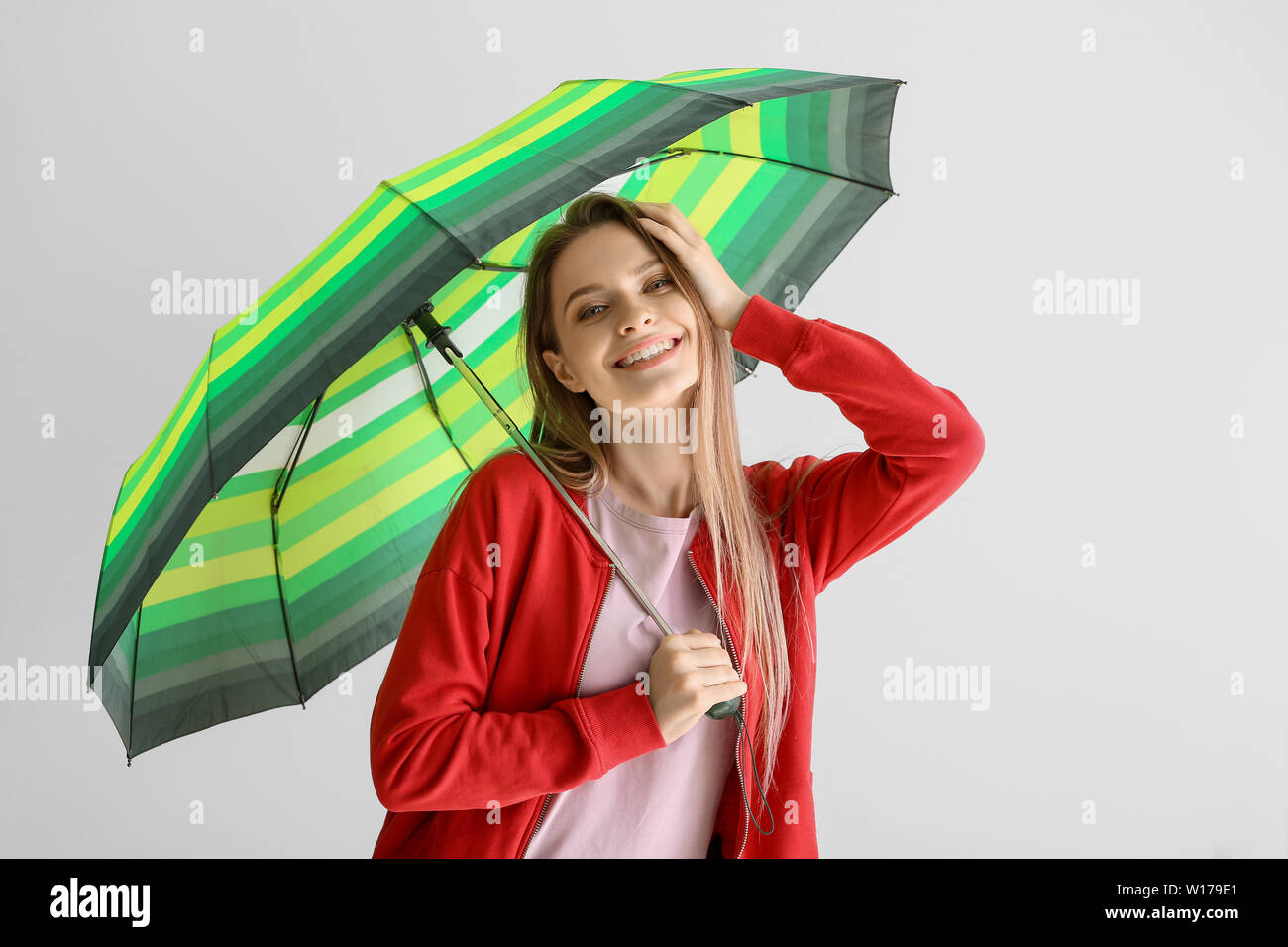Beautiful young woman with umbrella on white background Stock Photo - Alamy