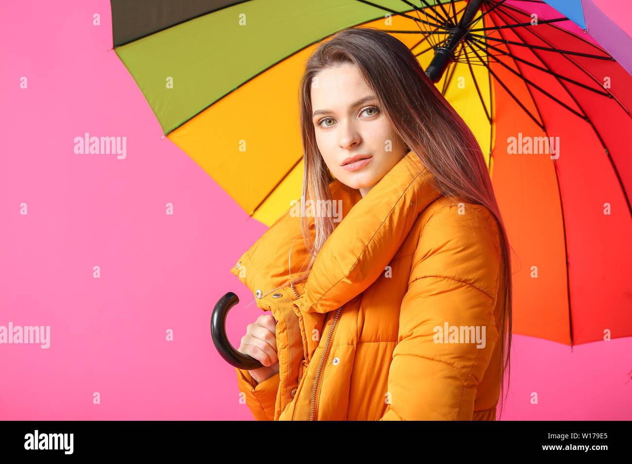 Beautiful young woman with umbrella on color background Stock Photo - Alamy