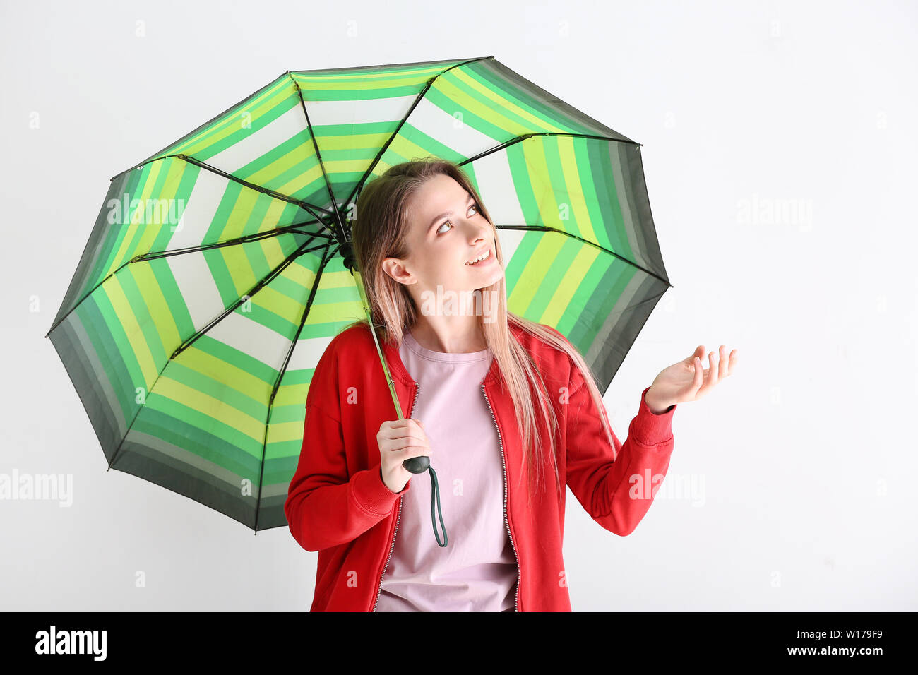 Beautiful young woman with umbrella on white background Stock Photo - Alamy