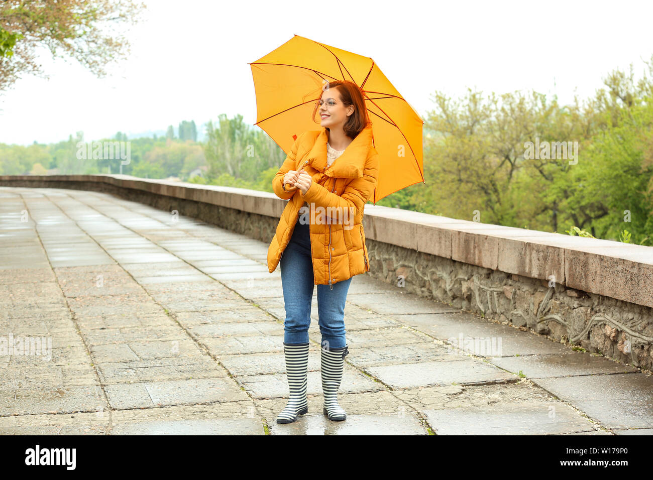 Beautiful young woman with umbrella outdoors on rainy day Stock Photo ...