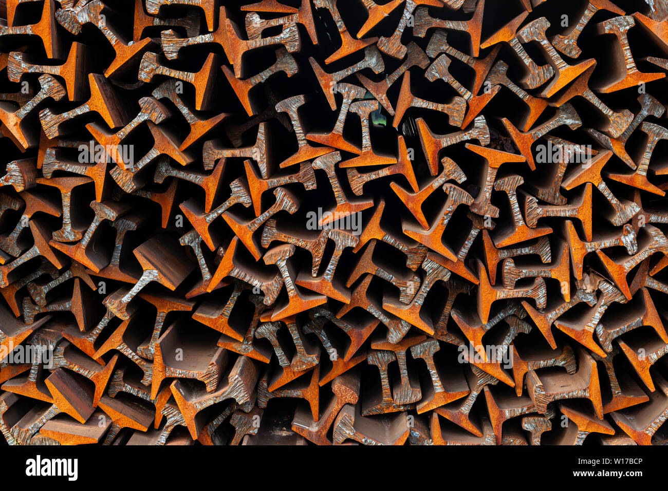A stack of scrap flat-bottomed rail in a large pile awaiting recycling. Stock Photo