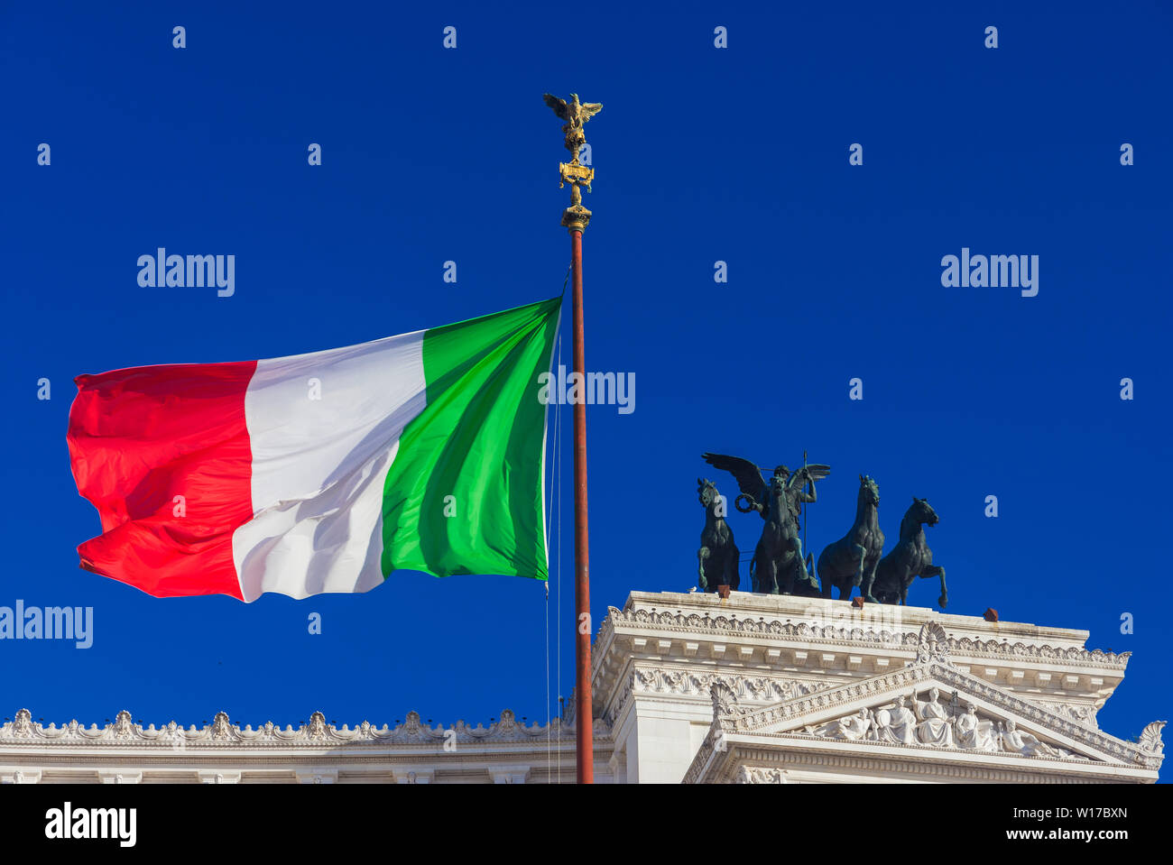 Nationalism and sovereignty in Italy. 'Tricolore' Italian national flag fluttering in the wind before Altar of Nation monument, symbol of fatherland Stock Photo