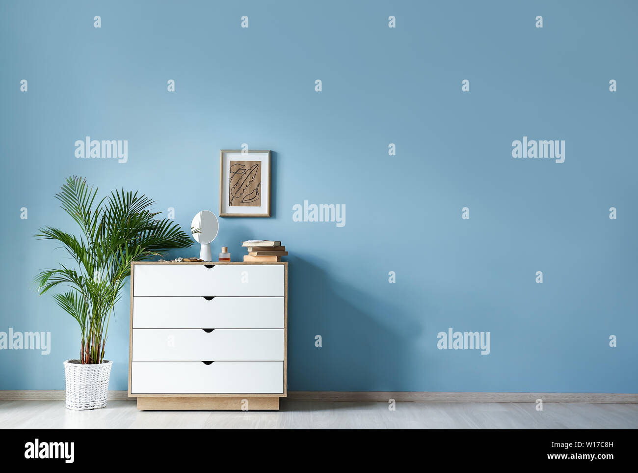Chest of drawers near color wall in room Stock Photo - Alamy