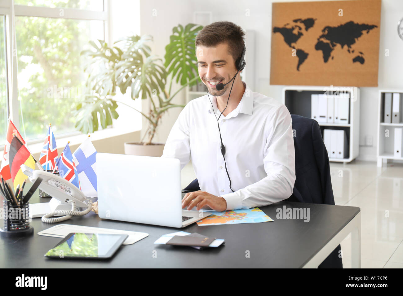 Male travel agent working in office Stock Photo