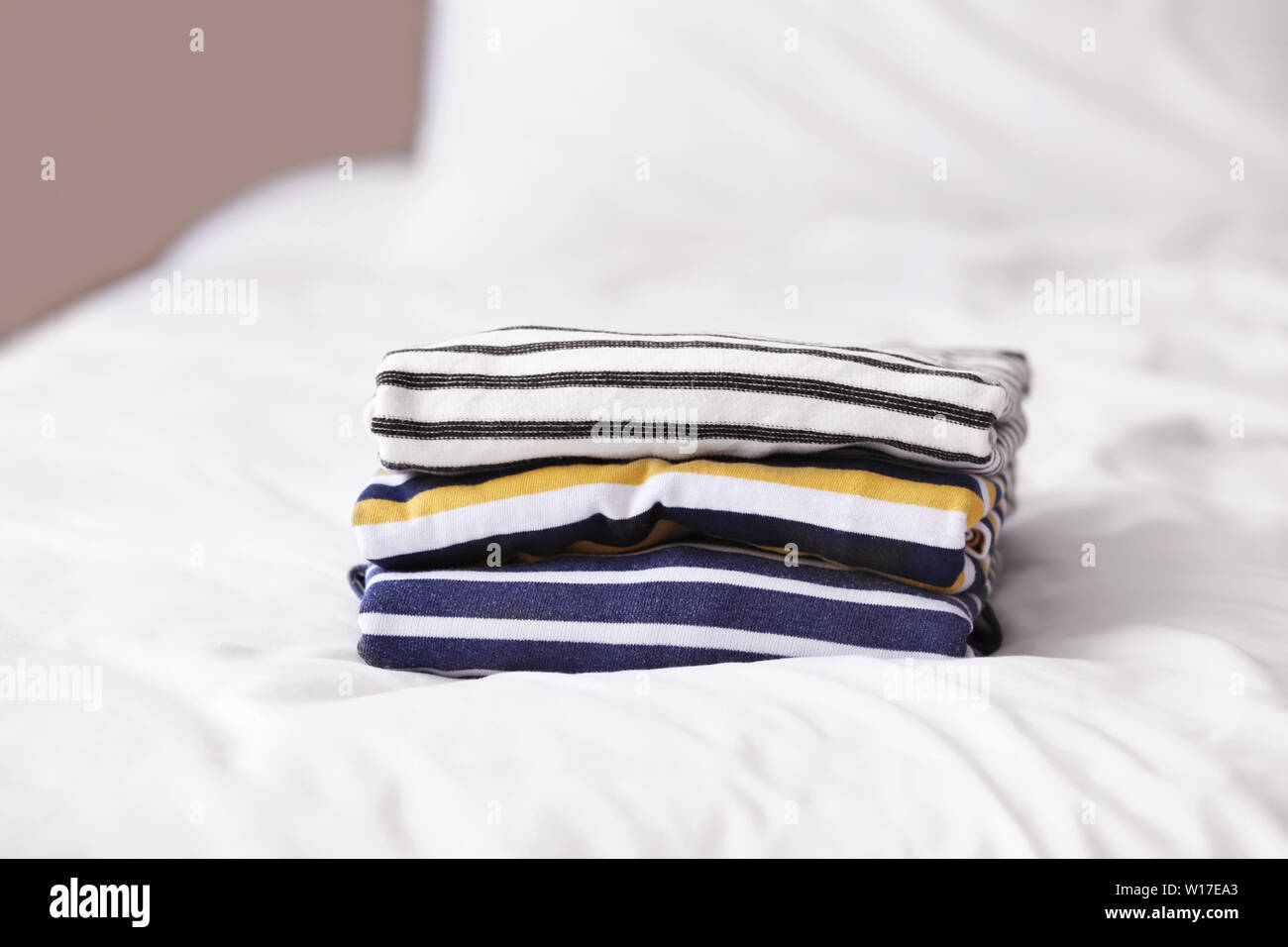 Stack of clean clothes on bed Stock Photo - Alamy
