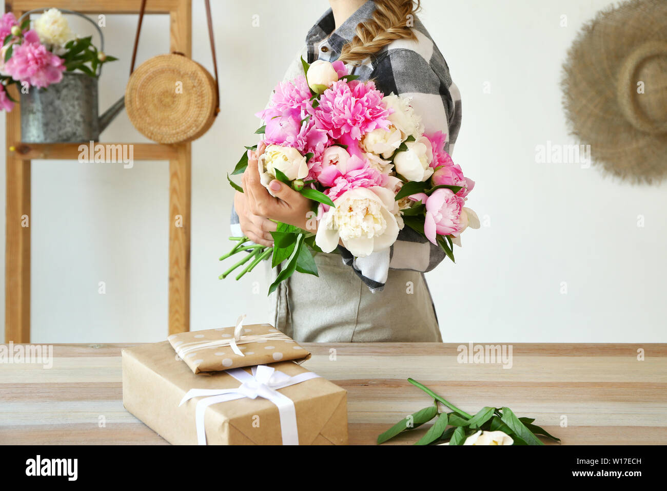 Female florist with beautiful bouquet of peonies in shop Stock Photo ...