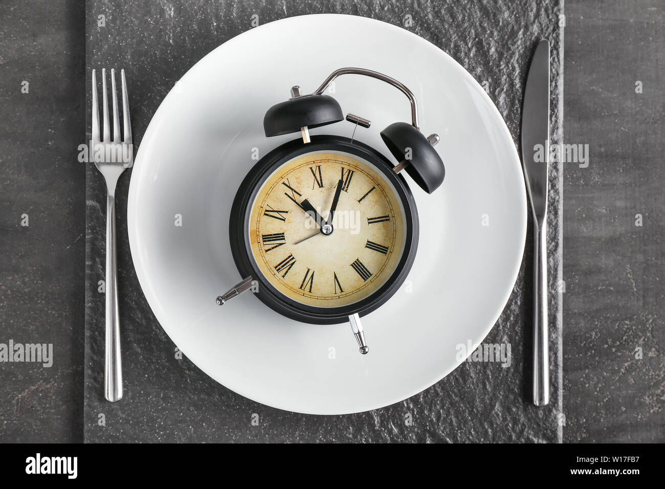 Simple table setting with alarm clock on dark background Stock Photo ...
