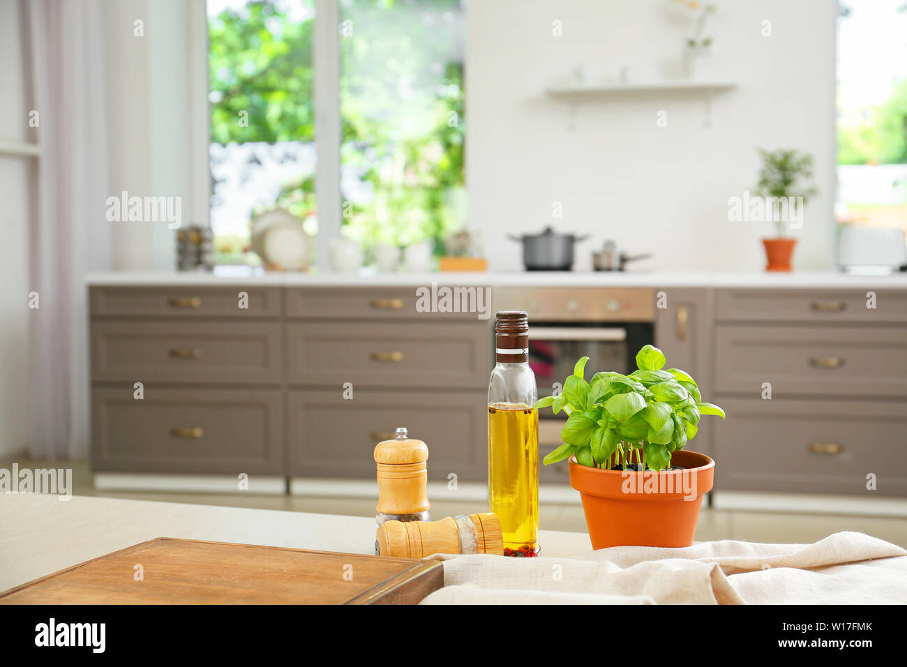 Fresh basil in pot with oil and spices on table in kitchen Stock Photo ...