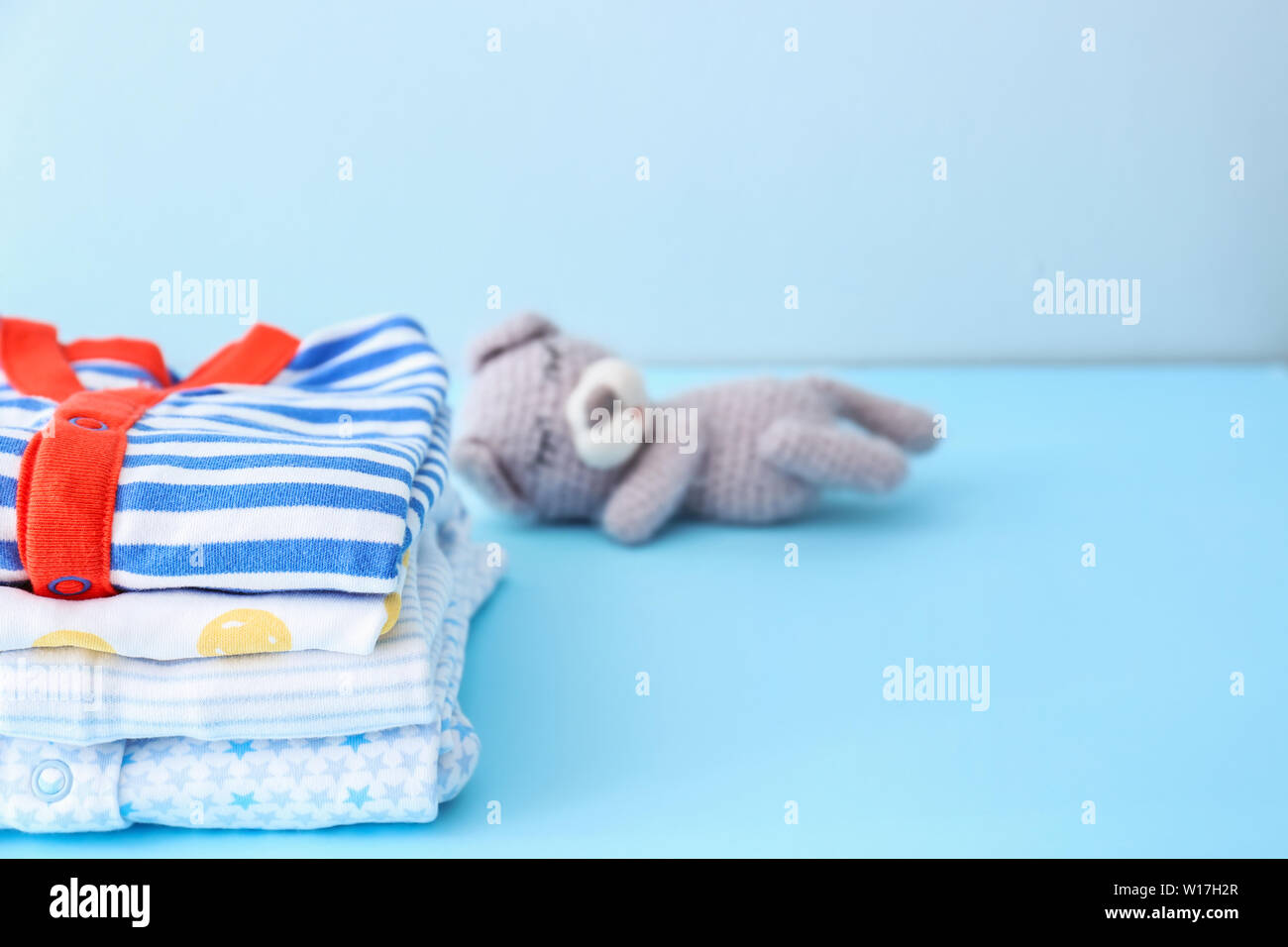 Stack of baby clothes on color background Stock Photo - Alamy
