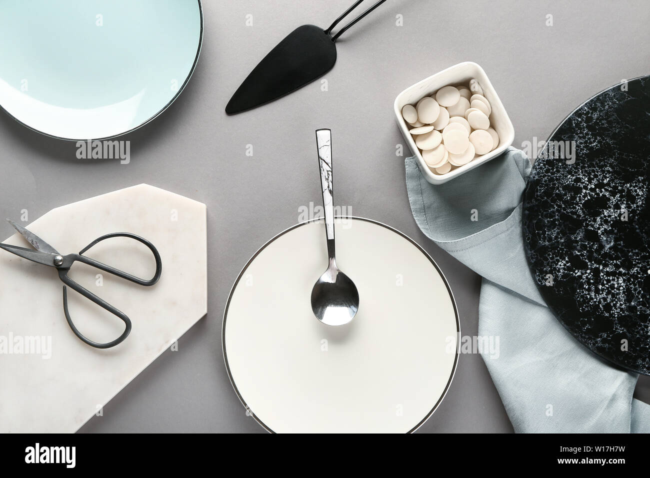 Different tableware and kitchen utensils on grey background Stock Photo