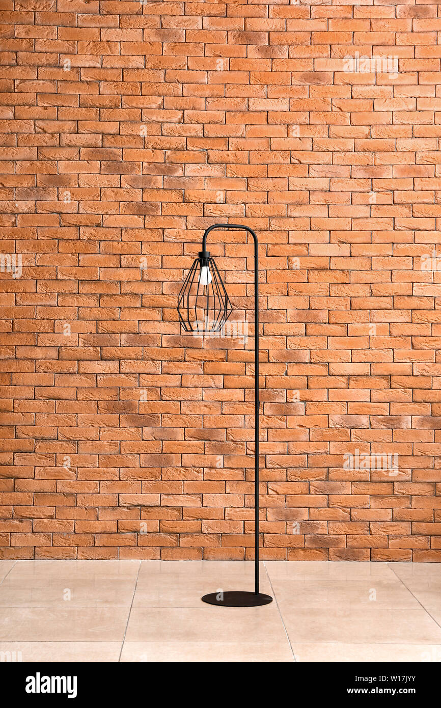 Beautiful stylish lamp against brick wall Stock Photo - Alamy - Luxury Exposed Brick Wall Floor Lamp Ideas For Home