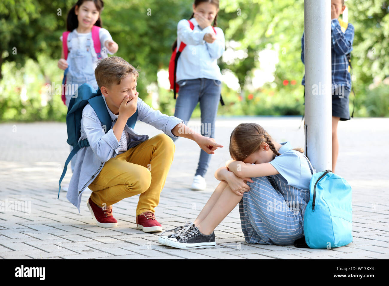 Bullied little girl with aggressive schoolmates outdoors Stock Photo ...