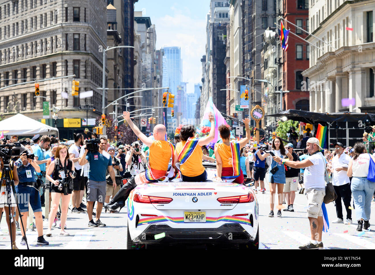 Participants ride on top of a car during the New York City Pride March on Fifth Avenue in New York City. Stock Photo