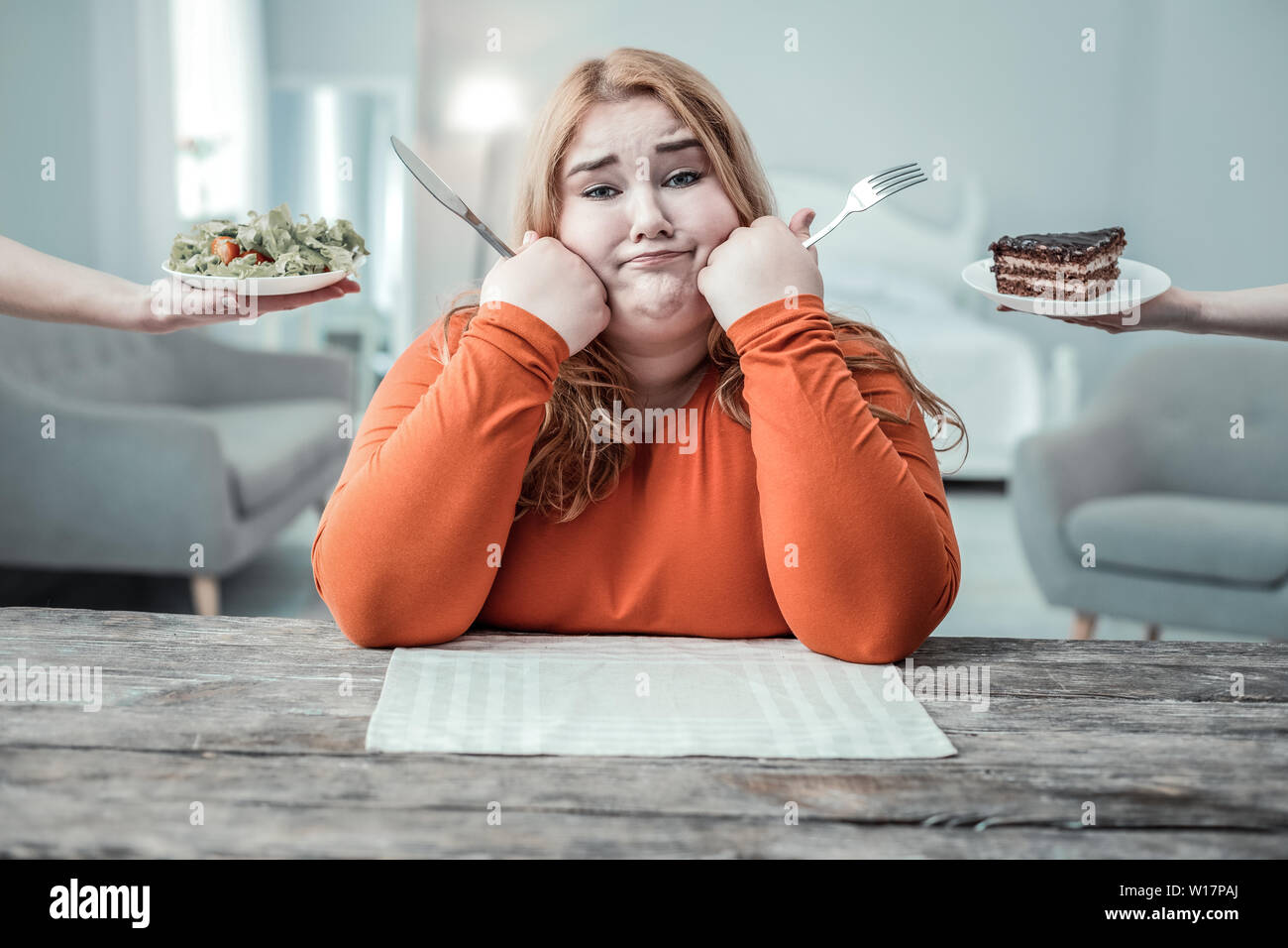 Bored overweight female person waiting for dinner Stock Photo