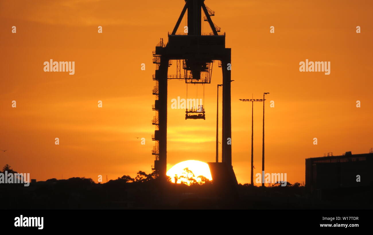 Melbourne industrial landscape. The sunsets behind a Port of Melbourne crane. Stock Photo