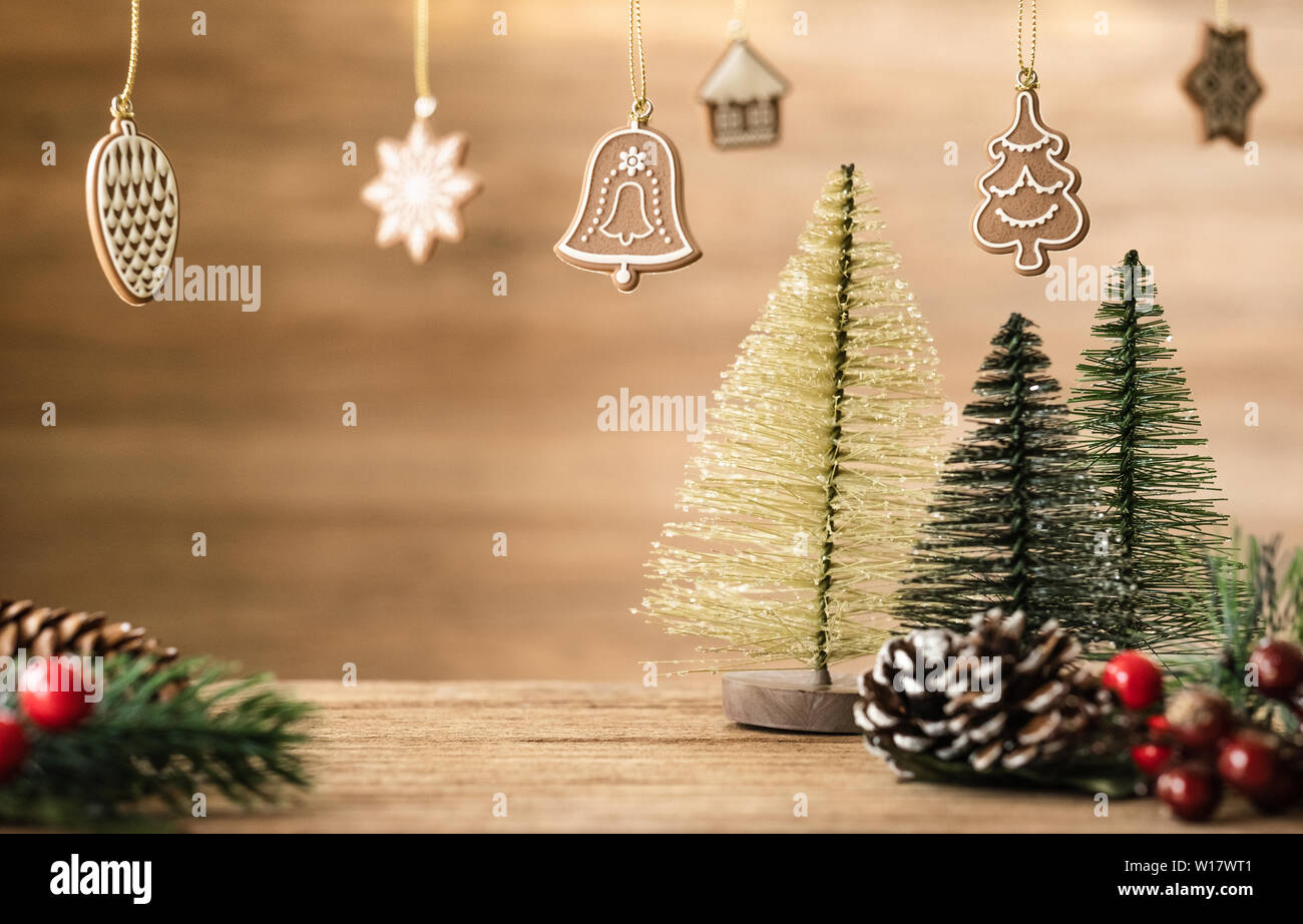 Christmas tree decoration on wood table with copy space.pine cone,mistletoe and bell ball hanging with blur wood wall background.Holiday greeting card Stock Photo