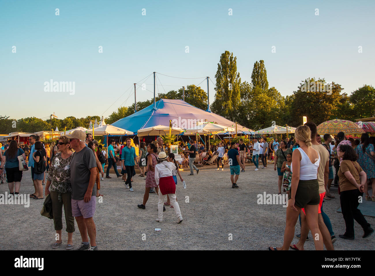 People walk on the festival grounds at sunset Stock Photo