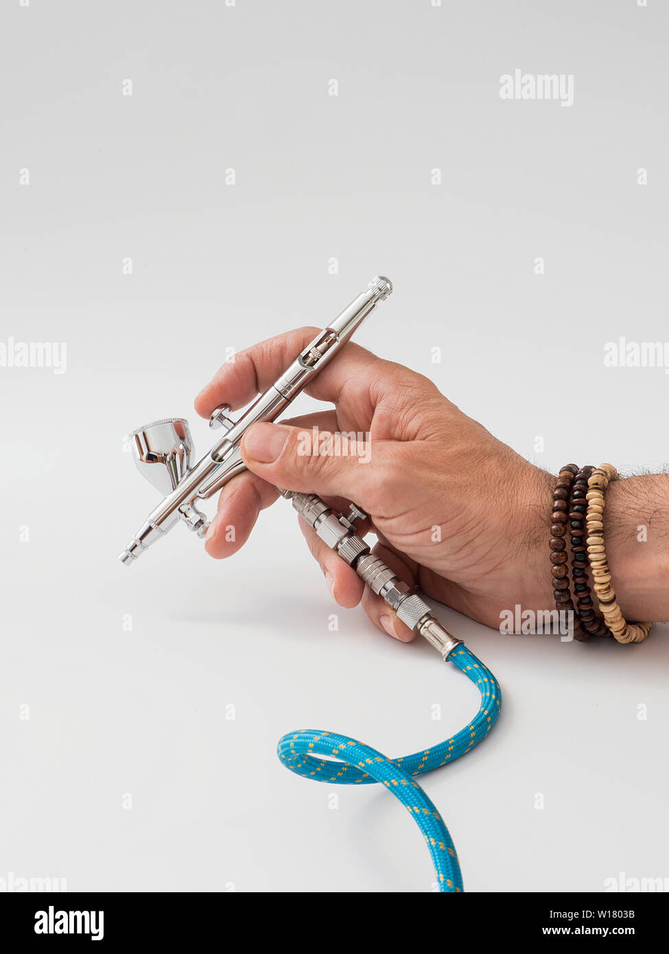 hand of a man holding an airbrush Stock Photo