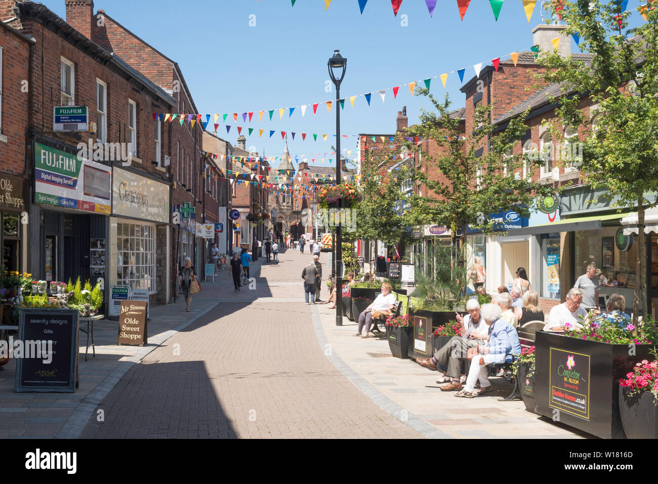 Older people sitting talking in Bridge Street, Congleton town centre, Cheshire, England, UK Stock Photo