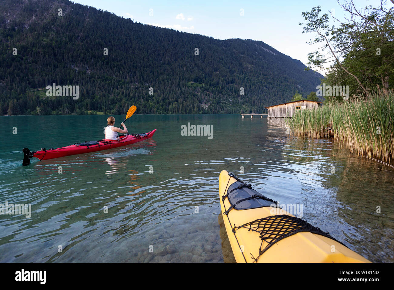 Woman kayaking at sunset in Weissensee Lake, Austria Stock Photo