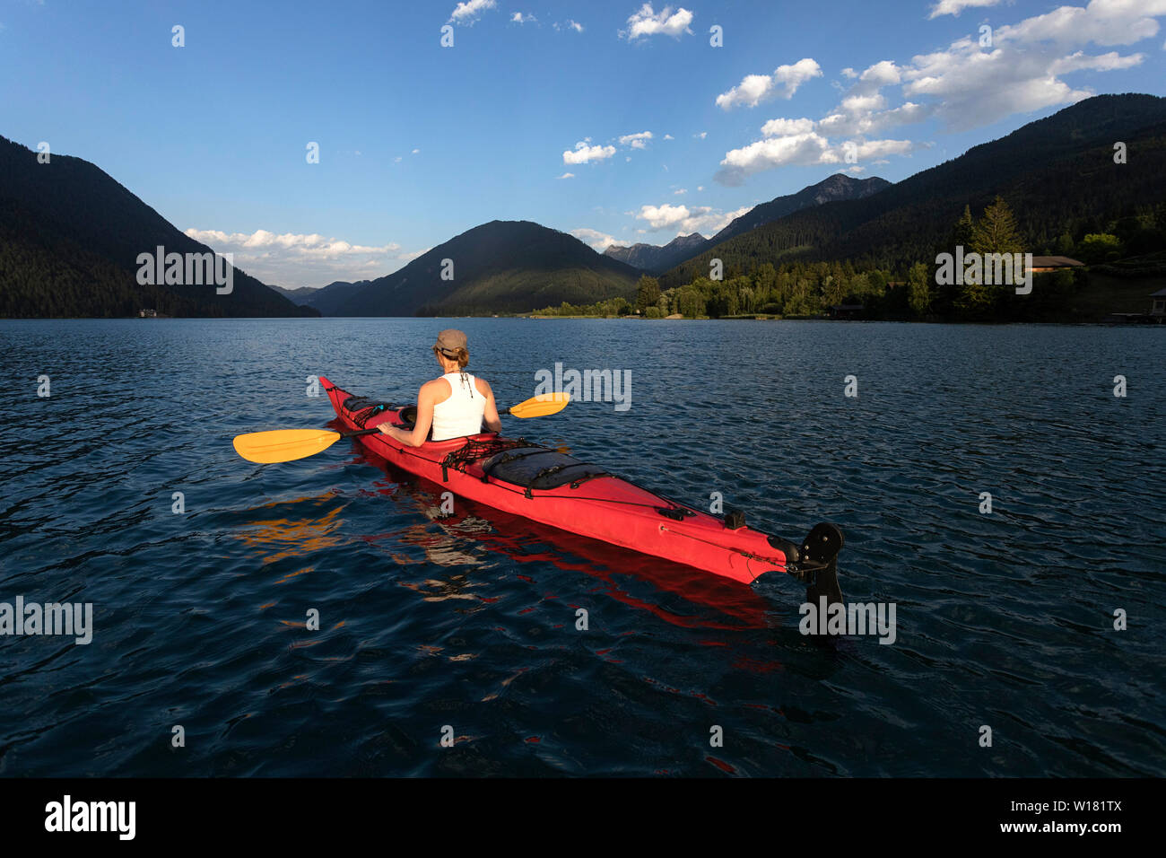 Woman kayaking at sunset in Weissensee Lake, Austria Stock Photo