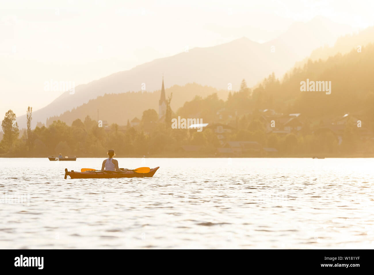 Woman kayaking at sunset in Weissensee Lake, Austria Stock Photo