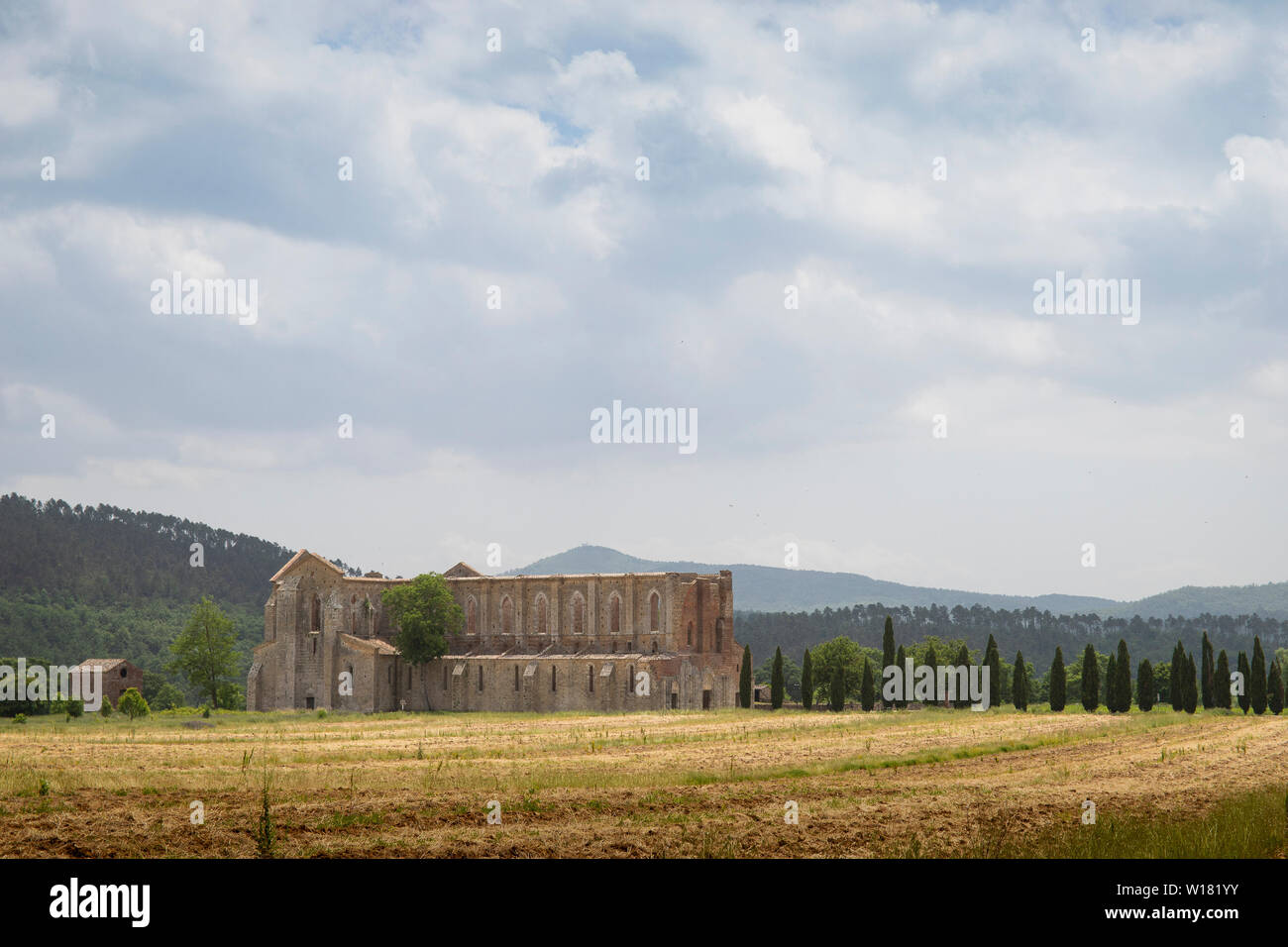 Distant landscape view of san galgano abbey in the fields with cloudy sky. Tuscany, Italy. Stock Photo
