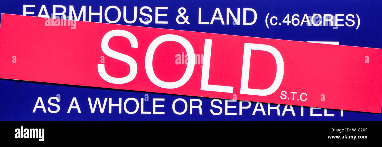 A sign saying farmhouse and land as been sold in the uk Stock Photo