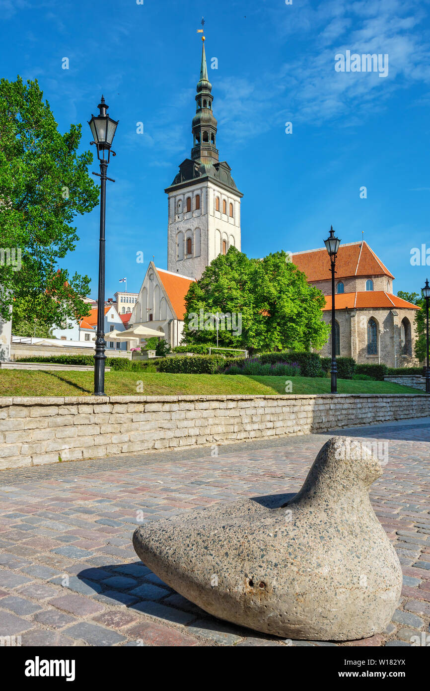 View to sidewalk with stone pigeon (used as street barrier). St. Nicholas church at the distance. Tallinn, Estonia Stock Photo