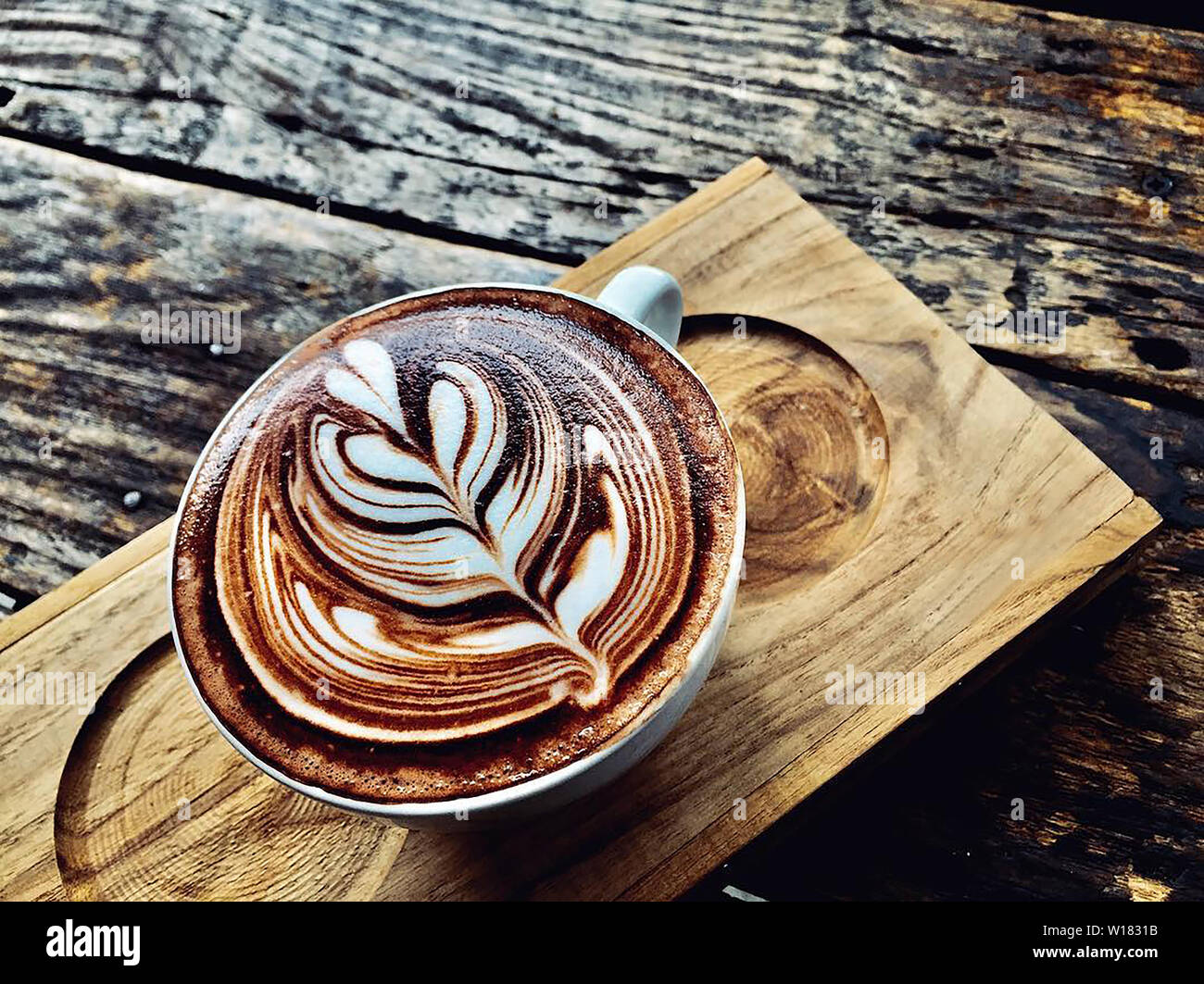 cup of coffee latte on dark wood table, beautiful latte art Stock Photo