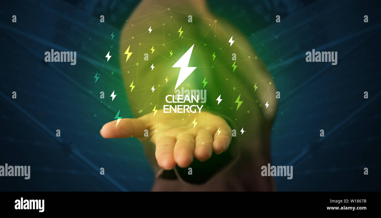Hand in suit holding lightning bolt on his hand, green environment concept  Stock Photo