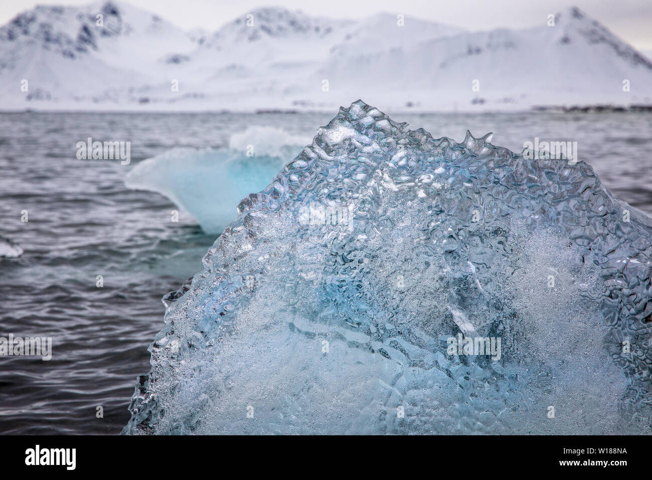 Details of iceberg fragments floating in the arctic sea. Blue glacial ice calved from the g;aciers of Svalbard, a Norwegian archipelago between mainla Stock Photo