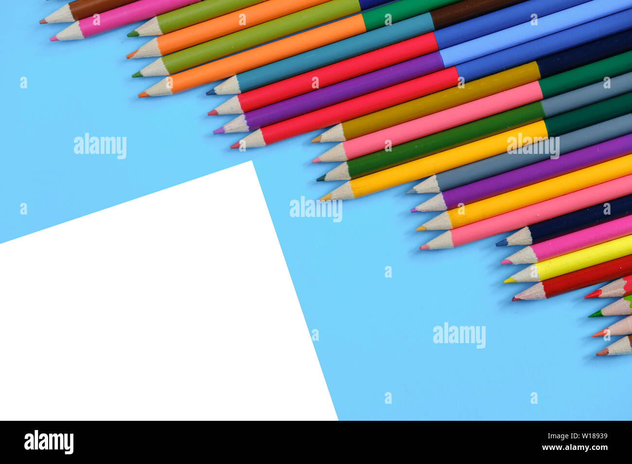 Creative flat lay back to school concept with colored pencils on blue ...