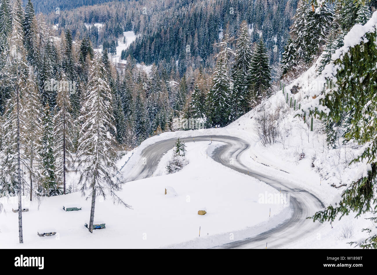 Sharp Curves along a Snowy Mountain Road. Concept of dangerous driving conditions. Stock Photo