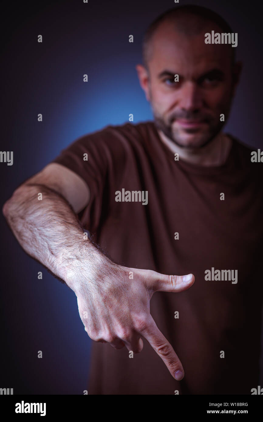 portrait of caucasian man gesture pose on dark background Stock Photo