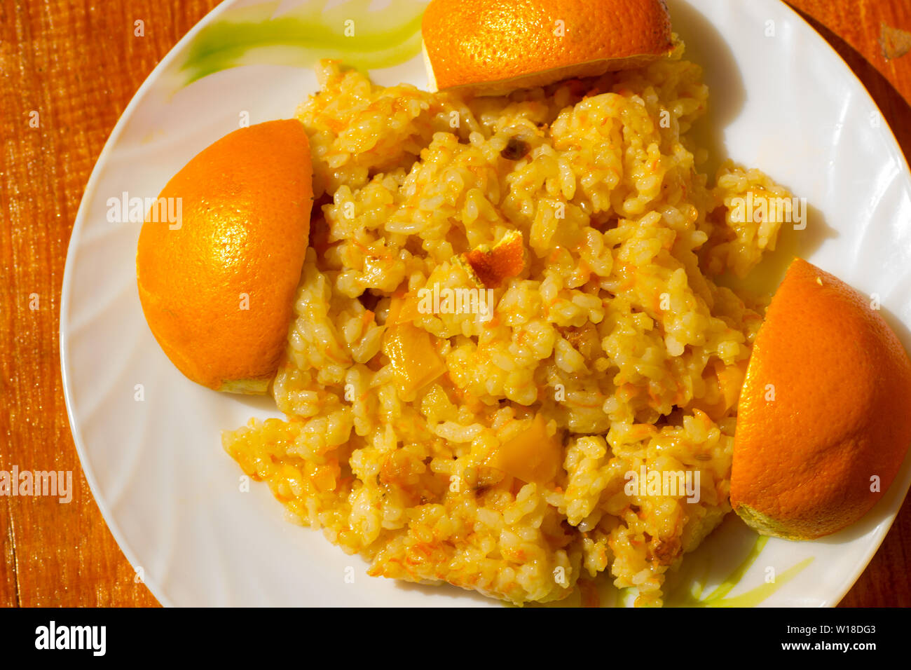 Lean pilaf with peppers and barberries on a plate decorated with oranges Stock Photo