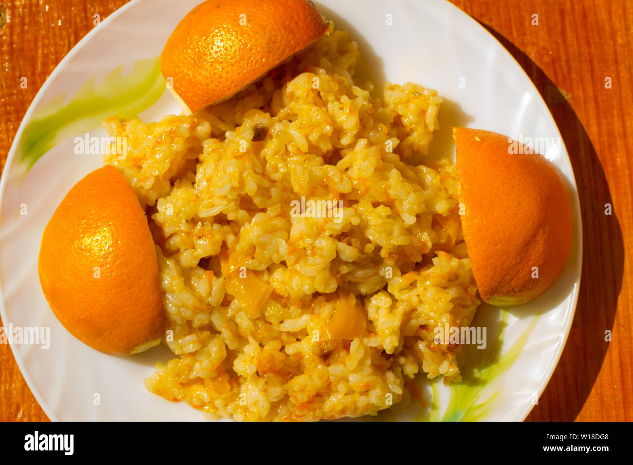 Lean pilaf with peppers and barberries on a plate decorated with oranges Stock Photo