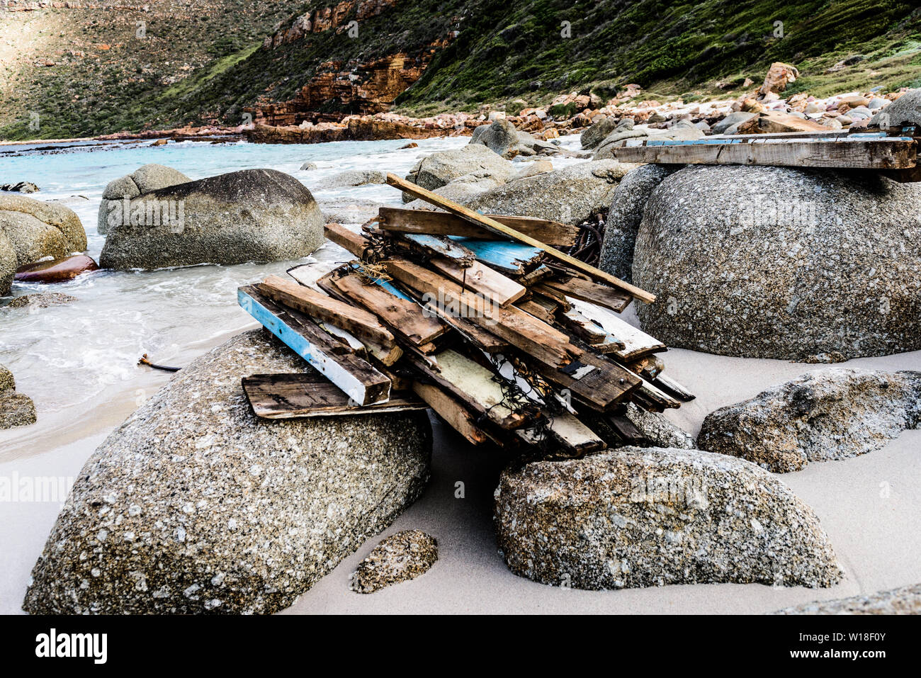 Driftwood is stacked on the rocks to dry at South Africa's Smitswinkel